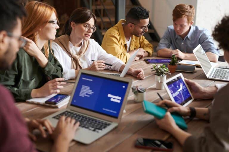 Interns working on laptops in a marketing office